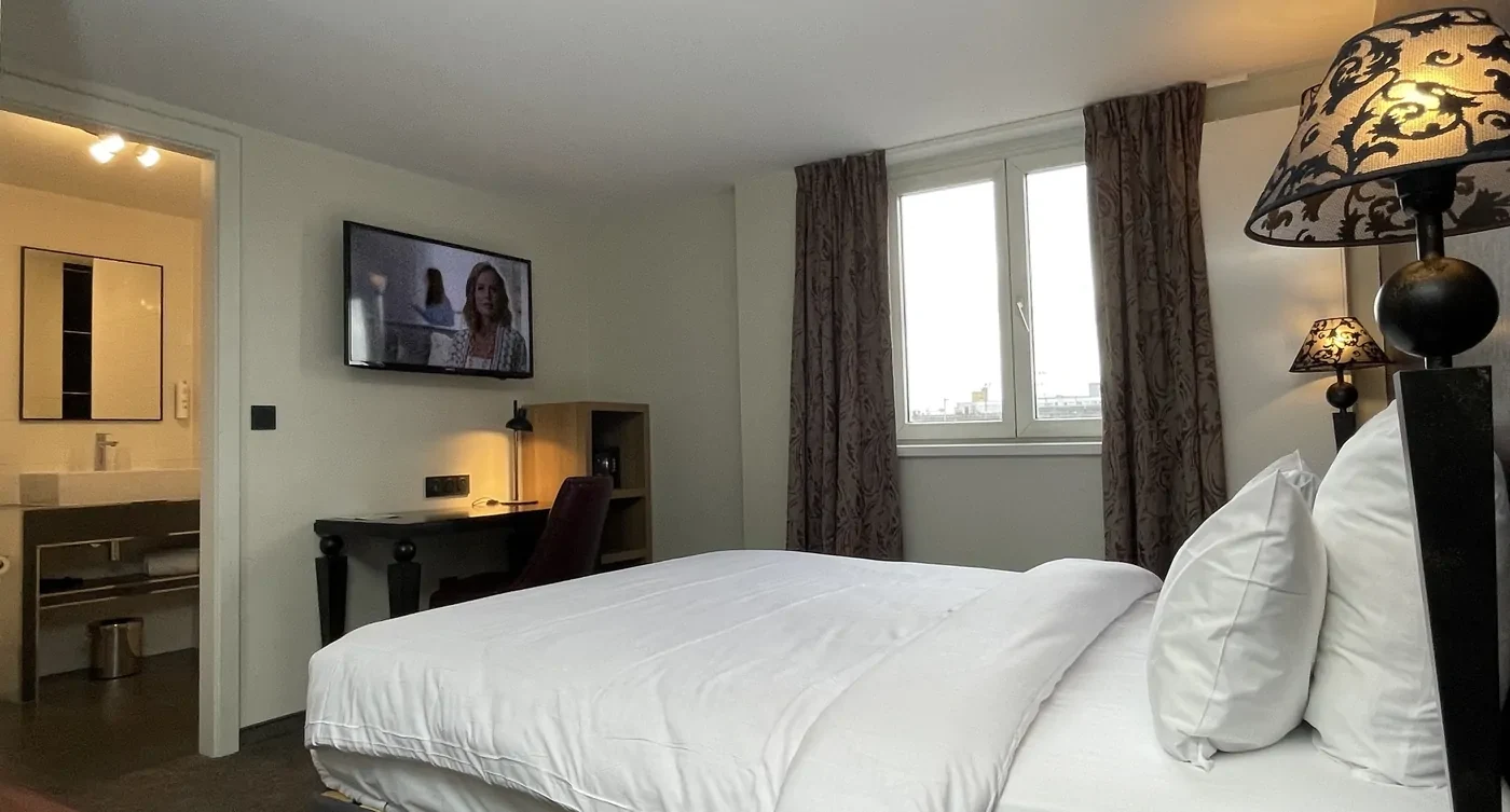 Téléviseur mural allumé dans une chambre aménagée.