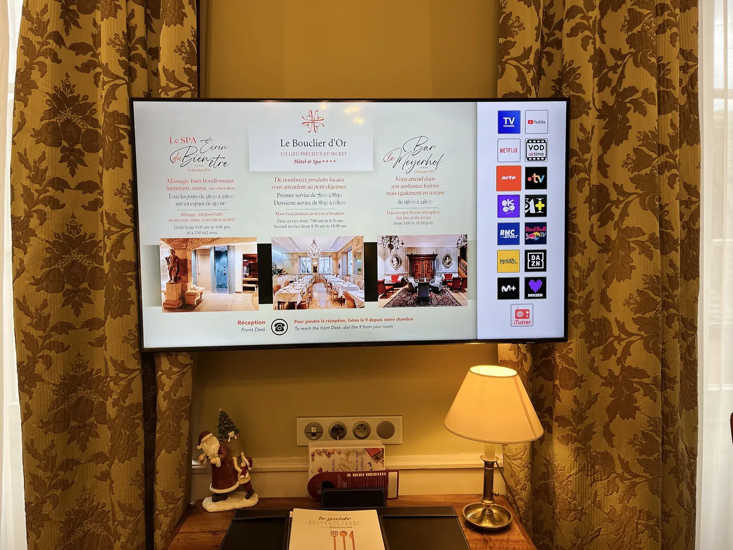 Téléviseur mural et accueil connecté dans une chambre du Bouclier d’Or.